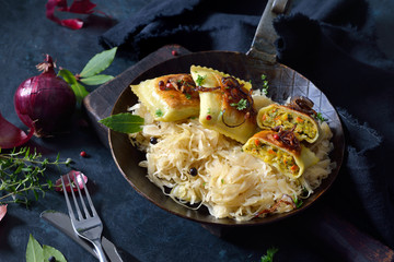 Gebratene schwäbische Gemüse-Maultaschen mit Röstzwiebeln auf Sauerkraut im Eisenpfandl ...