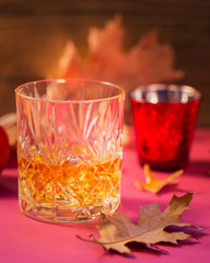 A glass of whiskey or bourbon, spices and decoration on dark background