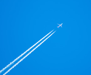 EasyJet airplane flying at high altitude leaving its white wake over blue sky