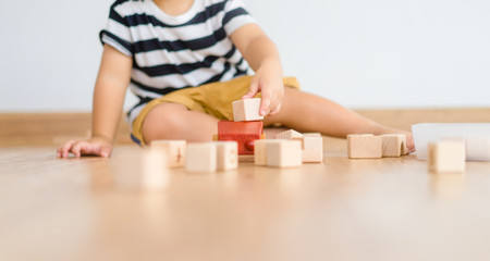 2 years baby boy.Little child boy playing with lots of wooden toys block with mother.Kids play with...