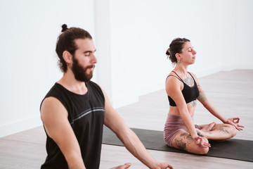 Fototapeta premium young man and woman practicing yoga sport at the gym. Healthy lifestyle