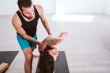 young man and woman practicing yoga sport at the gym. Healthy lifestyle