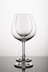 Empty wine glass throw another against white background