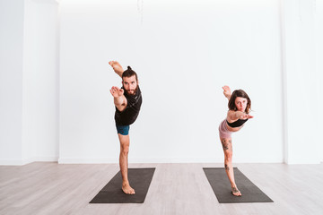 young man and woman practicing yoga sport at the gym. Healthy lifestyle
