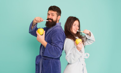 Brush teeth every morning. family couple hold apple with toothbrush. having healthy and strong teeth. personal care in morning. couple in bathrobe grooming. bearded man and girl healthy smile
