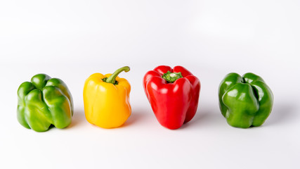 Four bell peppers that are different colors