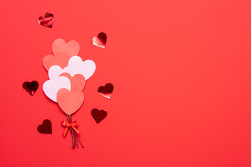 Valentine's day background with red and pink hearts like balloons on pink background, flat lay