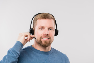 Happy young casual operator with headset consulting clients online in isolation