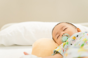 Sick child baby boy lying in bed with a fever in bed at hospital