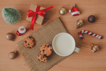 Top view of coffee cup with cookies and Christmas decoration on wood background.
