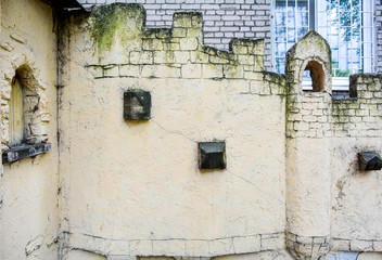 Fototapeta na wymiar Imitation of castle wall with tower window. Old castle on children playground