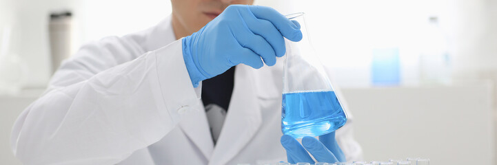 A male chemist holds test tube of glass