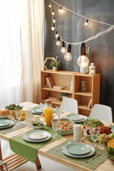 Festive table served for Thanksgiving or Christmas party with lamps above