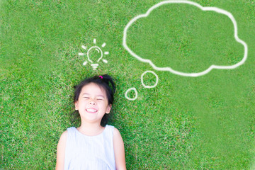 Smart asian girl lay down on green grass and thinking and discover good creative idea.World...