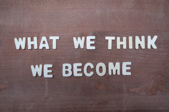 What we think, we become, Buddha quote composed with wooden letters on a wooden board