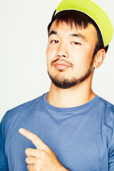 Fototapeta premium young asian man in hat and headphones listening music on white background