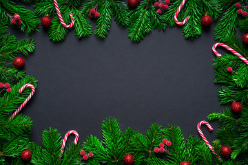 Fototapeta na wymiar Christmas frame border wirh fir branch, candy cane and baubles on black background