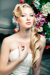 beauty young bride alone in luxury vintage interior with a lot of flowers, makeup and creative hairstyle