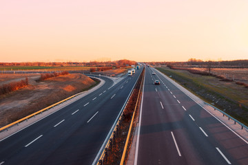 Busy highway with fast moving vehicles in beautiful sunset