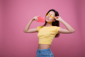 Beautiful portrait young asian woman wear sunglasses on head smile confident enjoy summer holiday isolated blue background, model girl fashion hipster holding passport, travel concept.