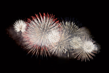 White and red fireworks display on dark sky background