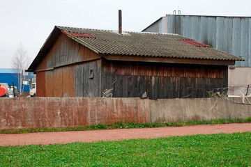 old wooden house behind a rickety concrete fence