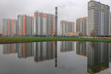 a residential complex of high-rise buildings reflected in the water