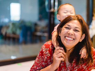 Happy loving family.Grandmother and grandson are having a good time together hugging and kissing at home.Grandson is smiling and laughing with his grandmother.