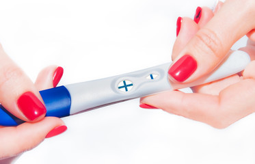Positive pregnancy test in female hands, close-up.