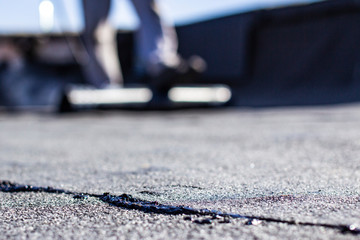 repair of bitumen roof with roll surfacing material with fire gas burner close-up, front and...