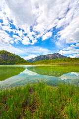 Fototapeta na wymiar Beautiful Offensee lake landscape with mountains, forest, clouds and reflections in the water in Austrian Alps. Salzkammergut region.