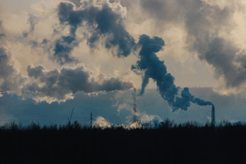 Factory chimneys pollute the atmosphere with dense smoke.