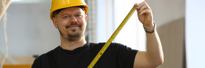 Arms of worker measuring wooden bar closeup