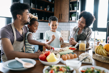 Happy family in the kitchen having fun and cooking together. Healthy food at home.