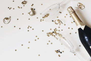 Happy New Year composition. Champagne glasses nad wine bottle with golden confetti stars isolated...