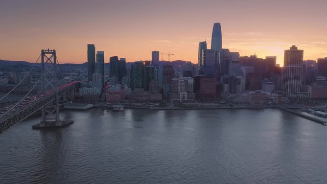 Aerial Drone Of The San Francisco City Skyline And Bay Bridge at sunset. Heavy traffic congestion is on the bridge.