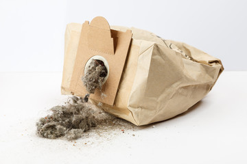 Used paper vacuum cleaner bag with garbage on white background