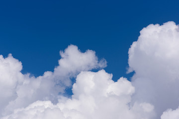 Naklejka na ściany i meble Beautiful cloudscape with white clouds on the dark blue sky, wallpaper with copy space