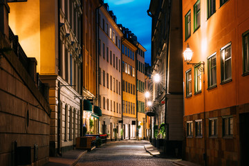 Fototapeta na wymiar Stockholm, Sweden. Night View Of Traditional Stockholm Street. Residential Area, Cozy Street In Downtown. Osterlanggatan Street In Historical District Gamla Stan