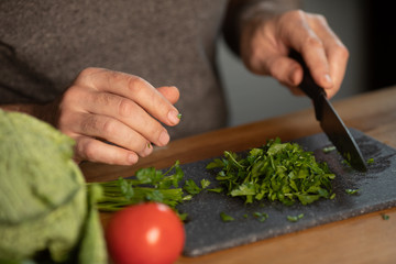 Bearded senior Man preparing healthy and tasty salad in kitchen.