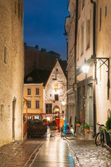 Tallinn, Estonia. View Of Raekoja Street With Old Ancient Medieval Houses In Evening Night Lights. Beautiful Old Narrow Streets Of Estonian Capital