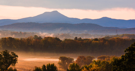 Fototapeta na wymiar early misty morning after sun rise with Camel's hump mountain in autumn 
