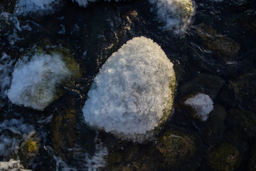 Frozen sea with snowy shores in Finland. Winter waves hitting the coast on a freezing cold sunny day. Ice and snow create unique shapes in the nature. Close-up macro photos with vibrant colors.