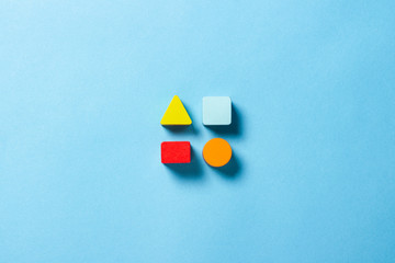 Children's educational toys geometric shapes for logic on a blue background. The concept of education, child development, logic and ingenuity. Flat lay, top view - obrazy, fototapety, plakaty