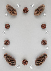 Christmas border with silver snowflakes and fir cones on a gray background. Happy New Year. Winter concept. Space for text.