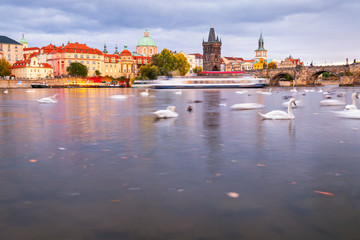 Beautiful view of Old Town buildings and Charles Bridge along the Vltava river at sunset in Prague