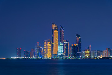 Abu Dhabi downtown night skyline reflected in the seaside