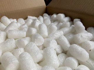 White polystyrene plastic foam elements within a parcel, to secure a safe transport.