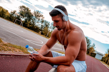 Athlete muscular man resting on the fitness ball after training