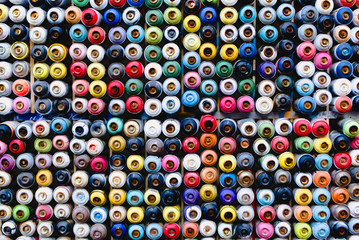 Colorful and textured background of a wall full of multicolored spray paint cans